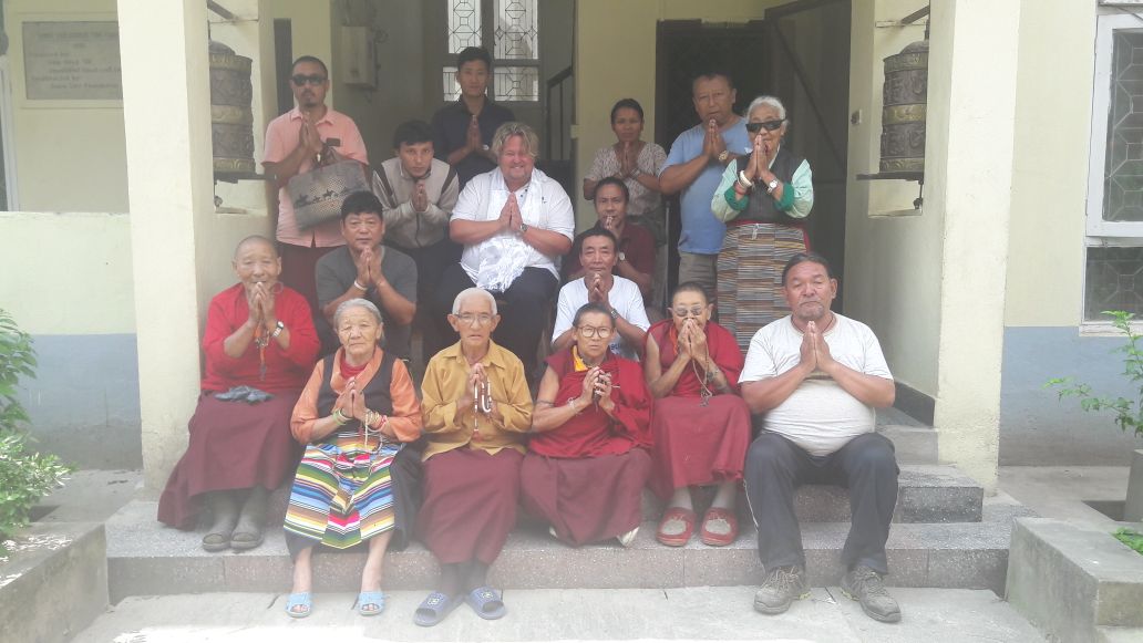 Residentes y visitantes reunidos en los escalones de una residencia para personas mayores
