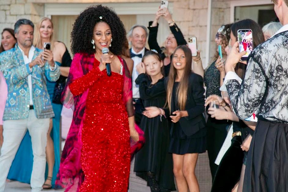 A singer in red performing among guests at Friends of MJ