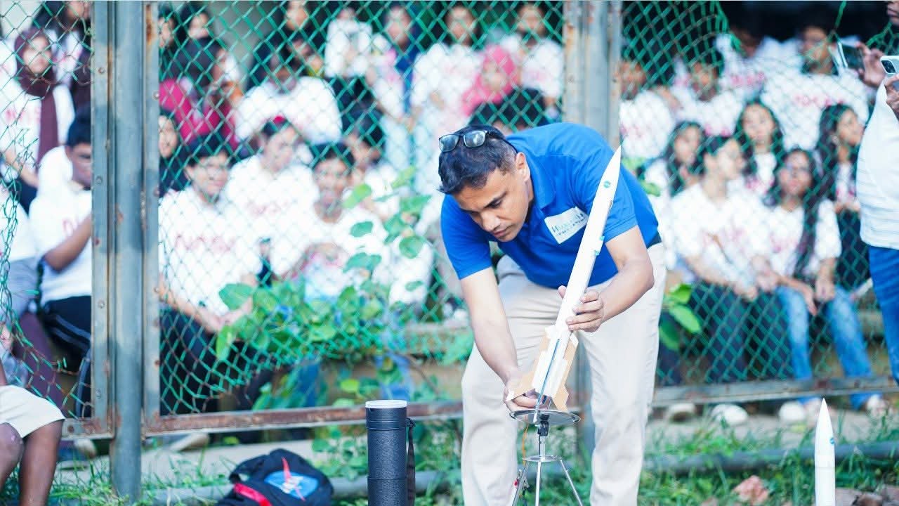 শিক্ষার্থীদের সামনে মডেল রকেট প্রস্তুত করছেন একজন নির্দেশক