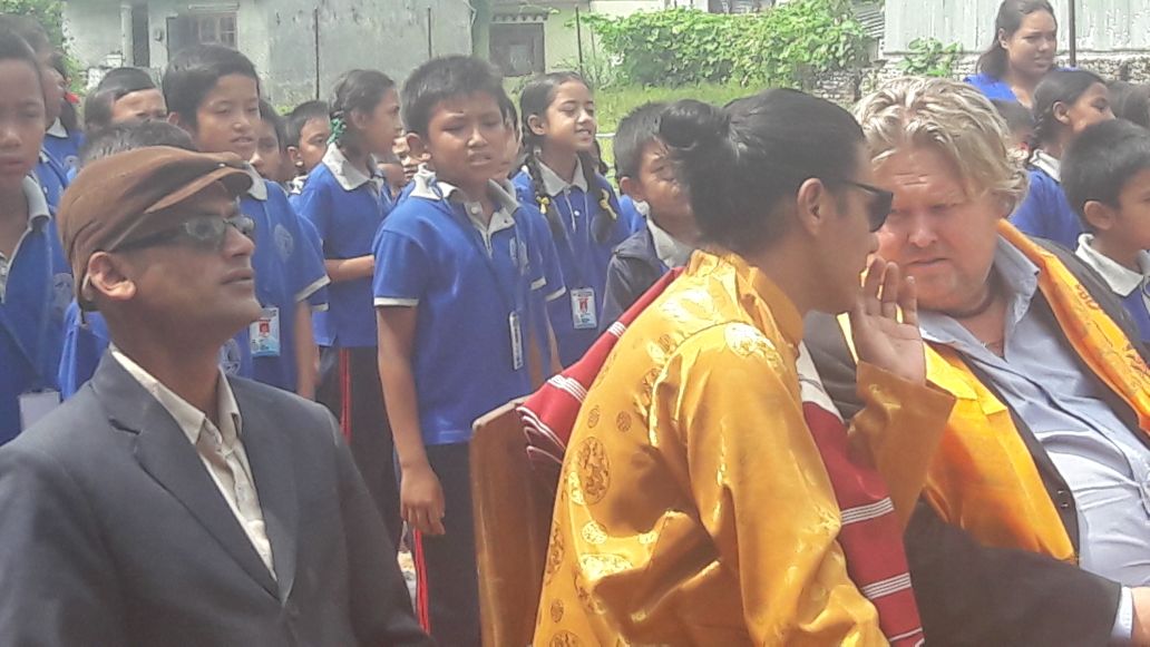 Para pengunjung berbincang, sementara anak-anak sekolah berada di dekatnya