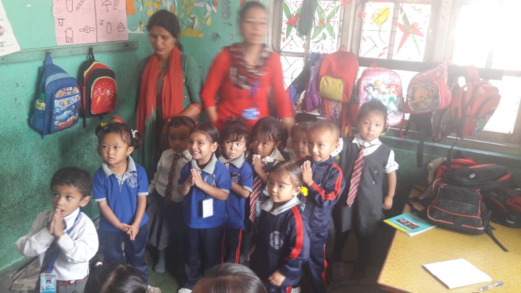 Anak-anak kecil dan pendidik berkumpul di ruang kelas