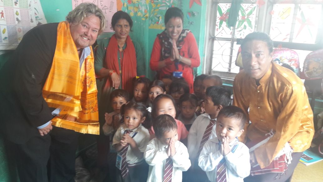 Anak-anak, pendidik, dan pengunjung berpose bersama di ruang kelas