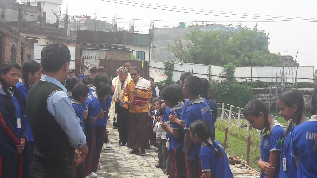 Anak-anak menyambut pengunjung di luar sekolah