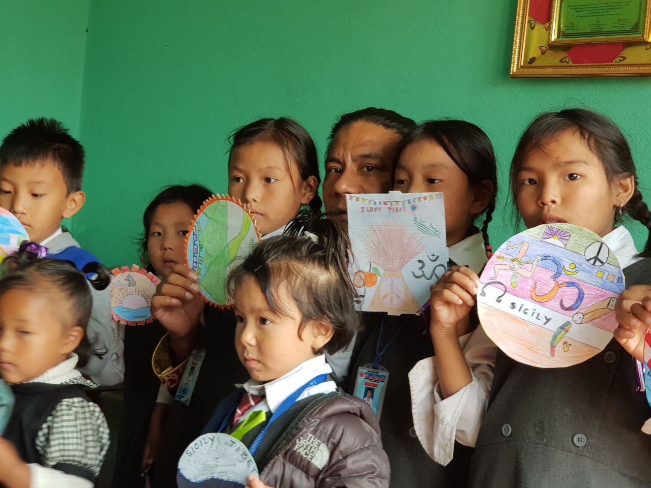 Anak-anak memegang gambar berwarna di ruang kelas